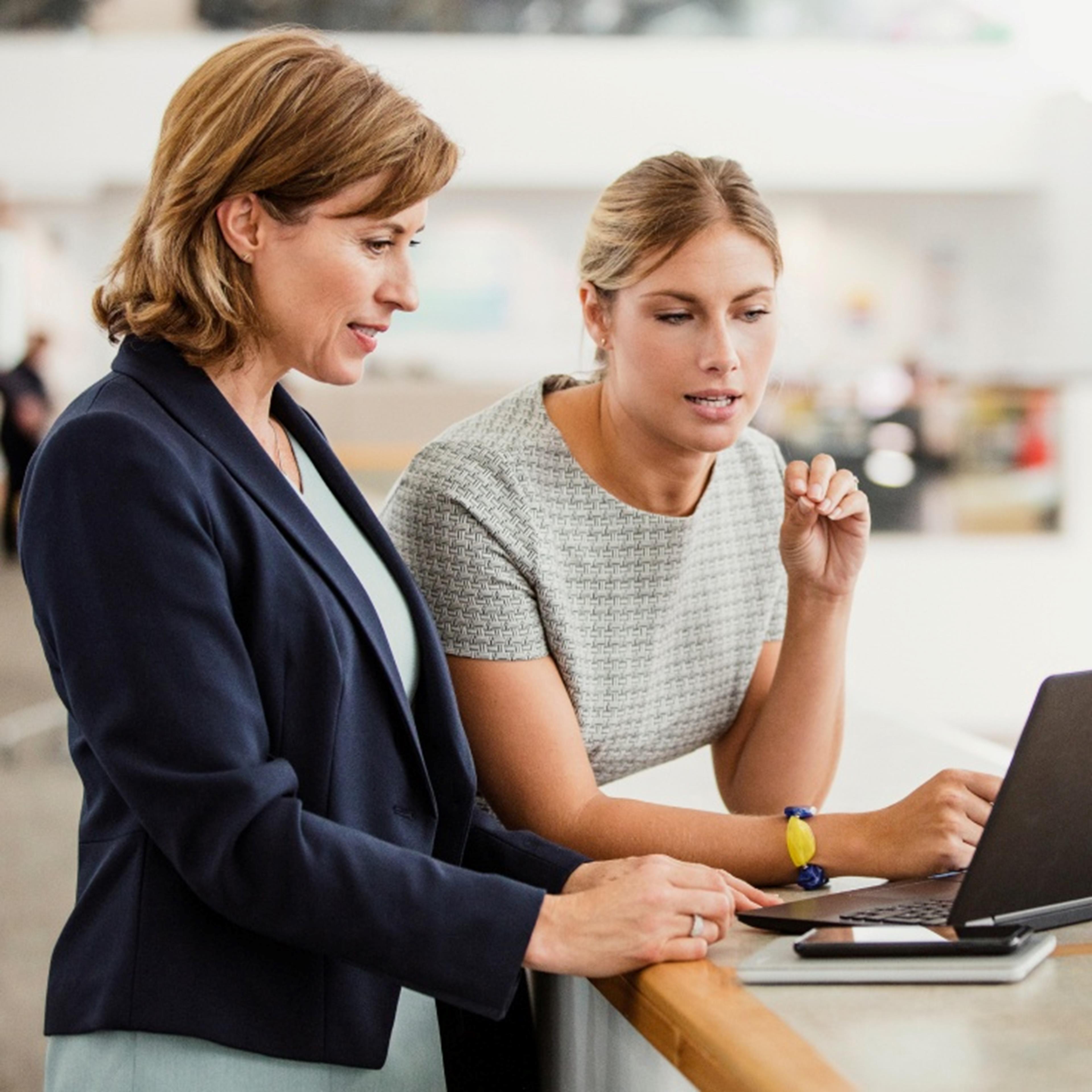 two women looking at a laptop